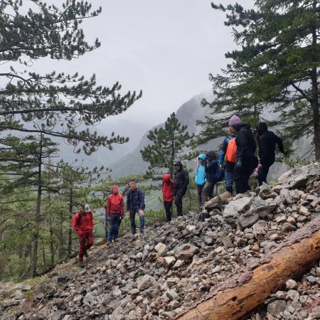 Gruppe steht an der Kante und Wegeerhaltungsmaßnahmen werden erklärt